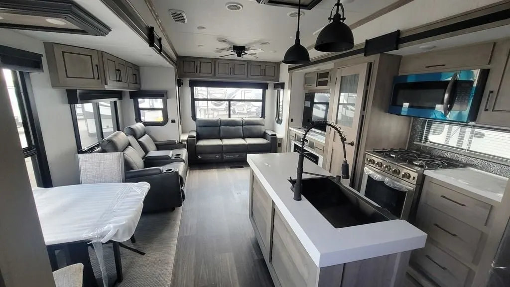 Interior view of the RV with a dinette, living space and a kitchen.