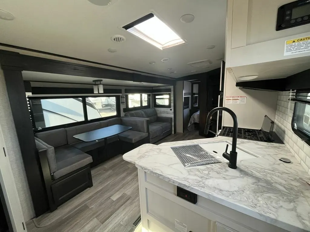 Interior view of the RV with a dinette, living space and a kitchen.