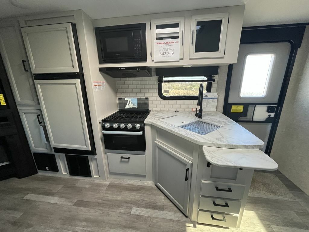 Kitchen with a gas burner, fridge, oven, sink and cabinets.