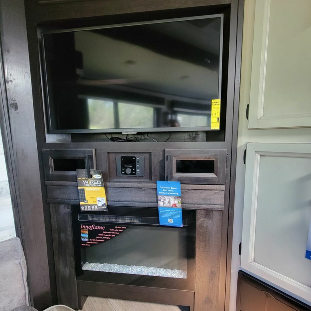 Entertainment center with a TV and a fireplace.