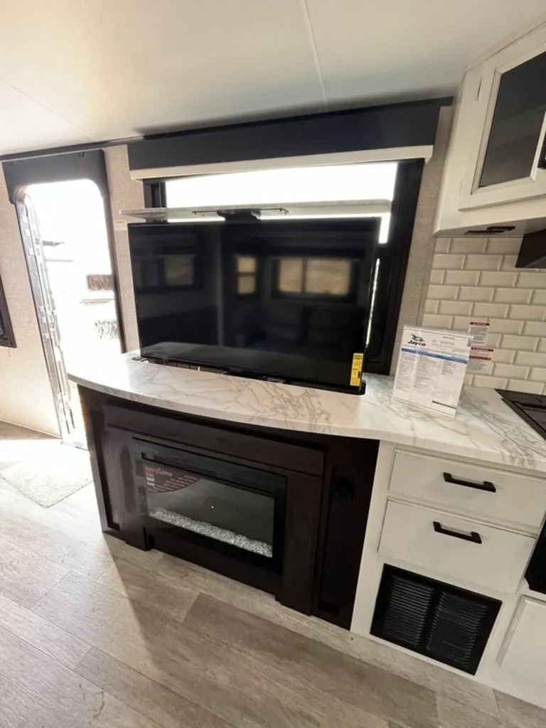 Entertainment center with a TV and a fireplace.