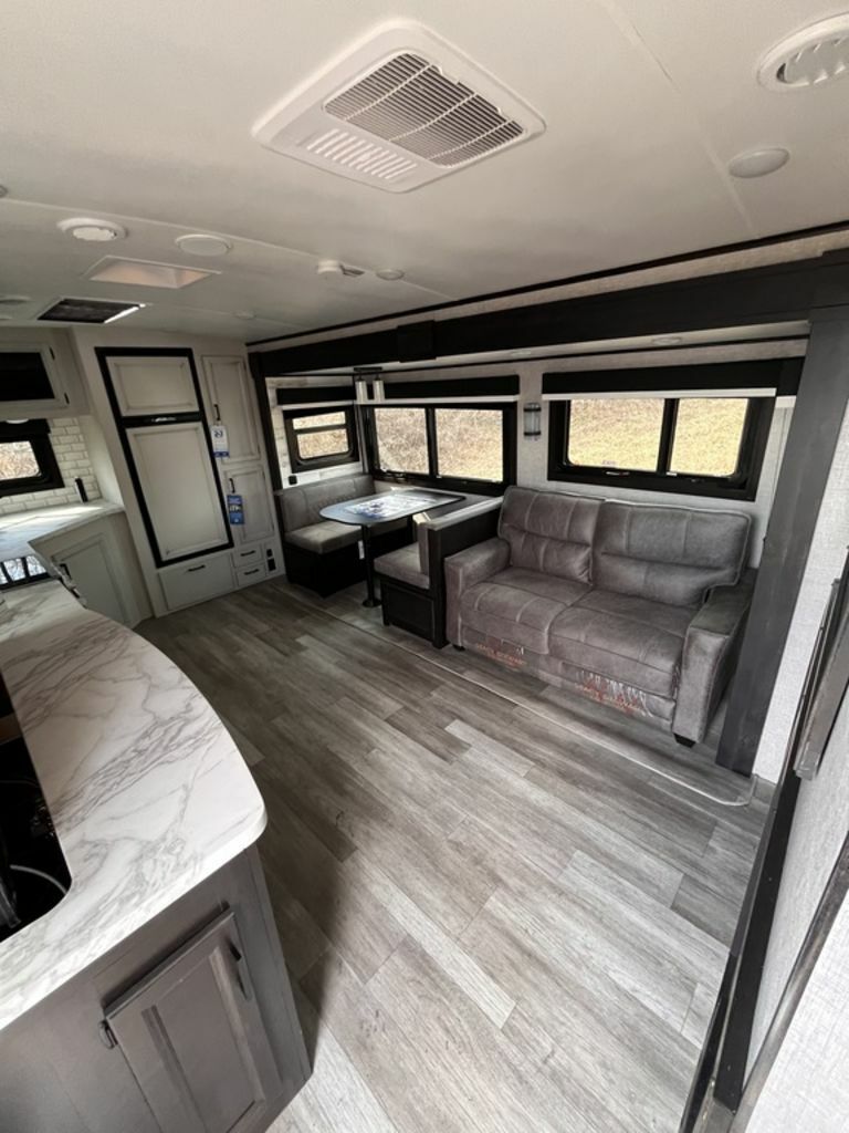 Interior view of the RV with a dinette, living space and a kitchen.