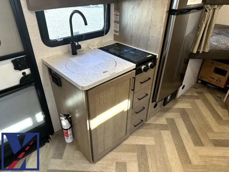 Kitchen with a gas range, fridge, sink and cabinets.