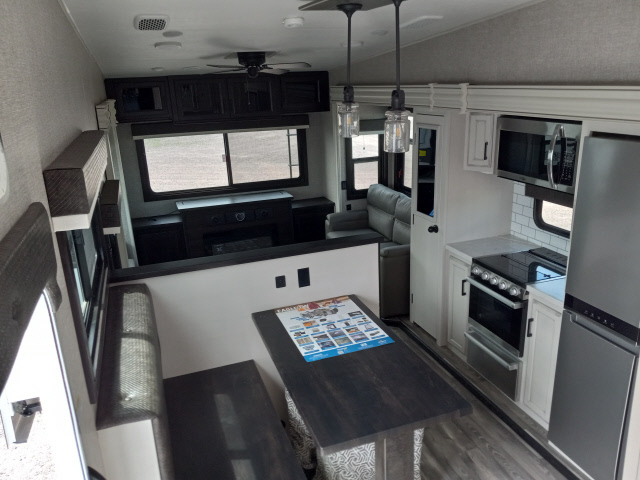 Interior view of the RV with a dinette, living space and a kitchen.