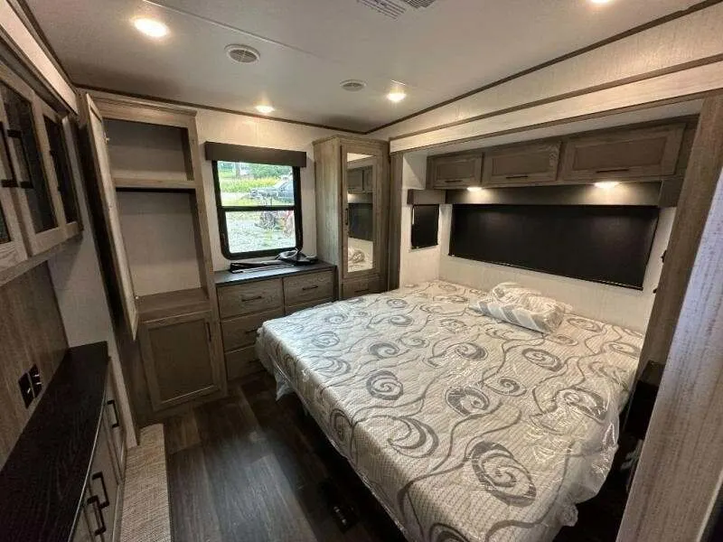 Bedroom with a king size bed, overhead cabinets and a closet.