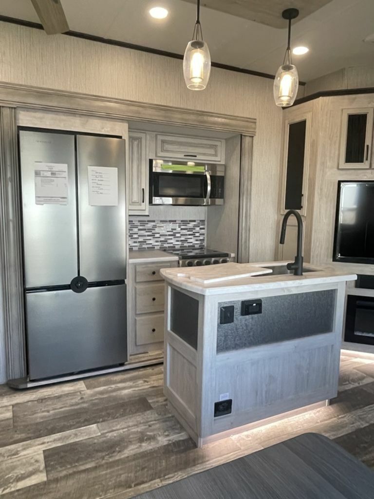 Kitchen with a gas burner, fridge, oven, sink and cabinets.