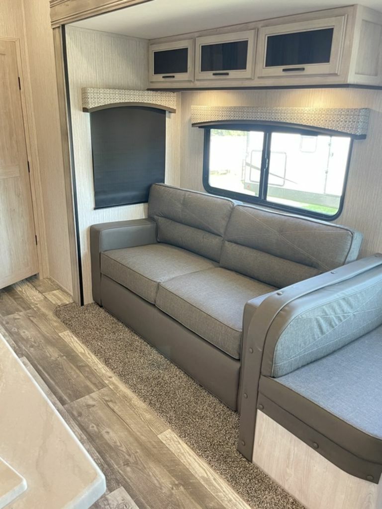 Living space with leather seats and overhead cabinets. 