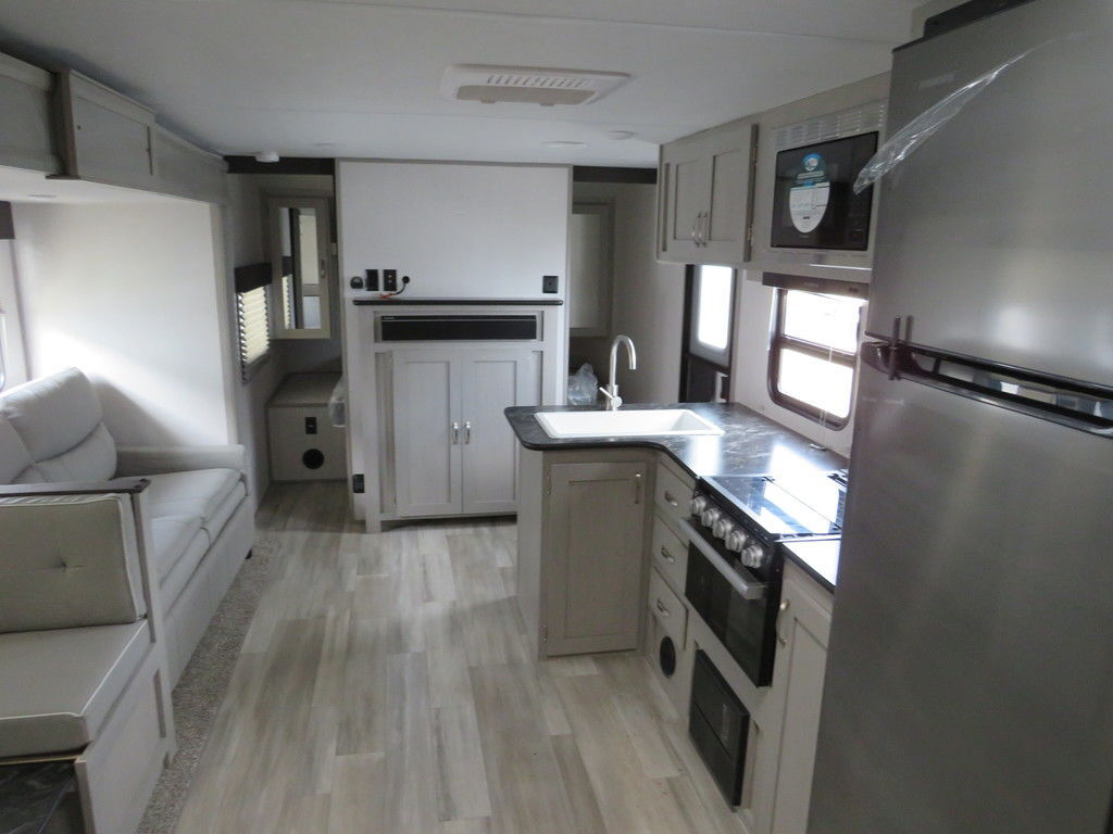 Interior view of the RV with a dinette, living space and a kitchen.