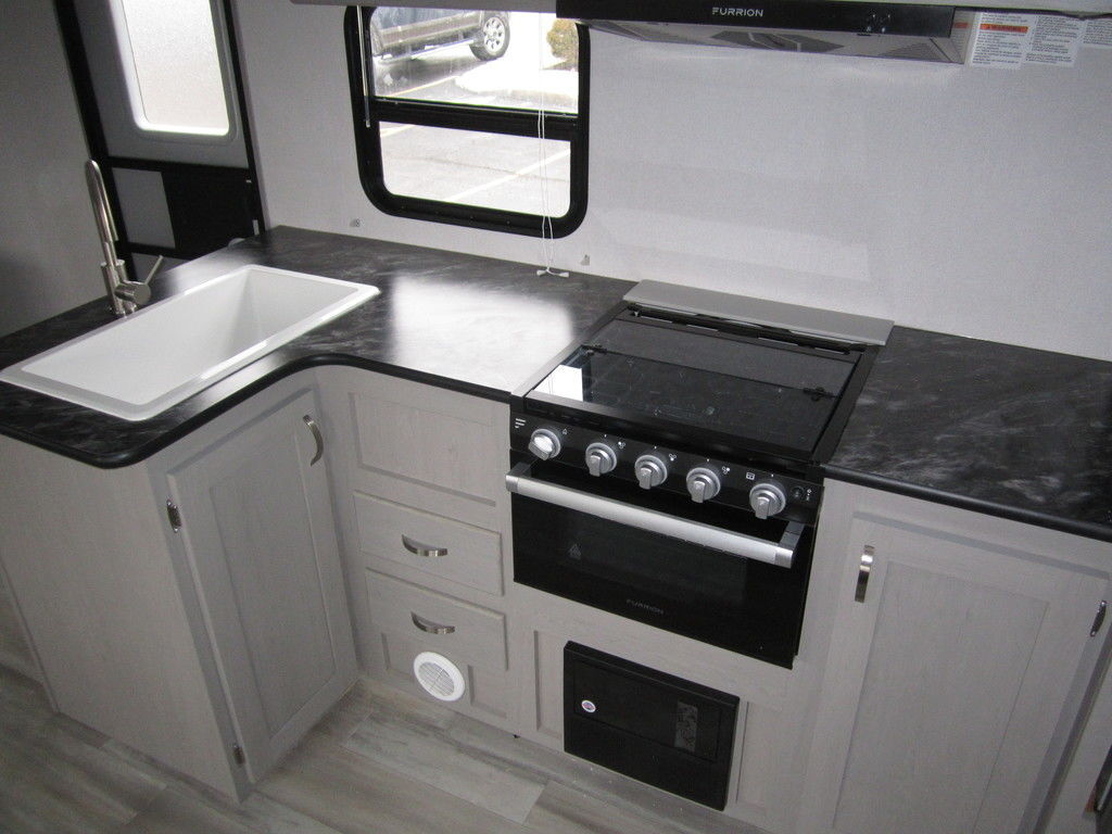 Kitchen with a gas range, sink and cabinets.