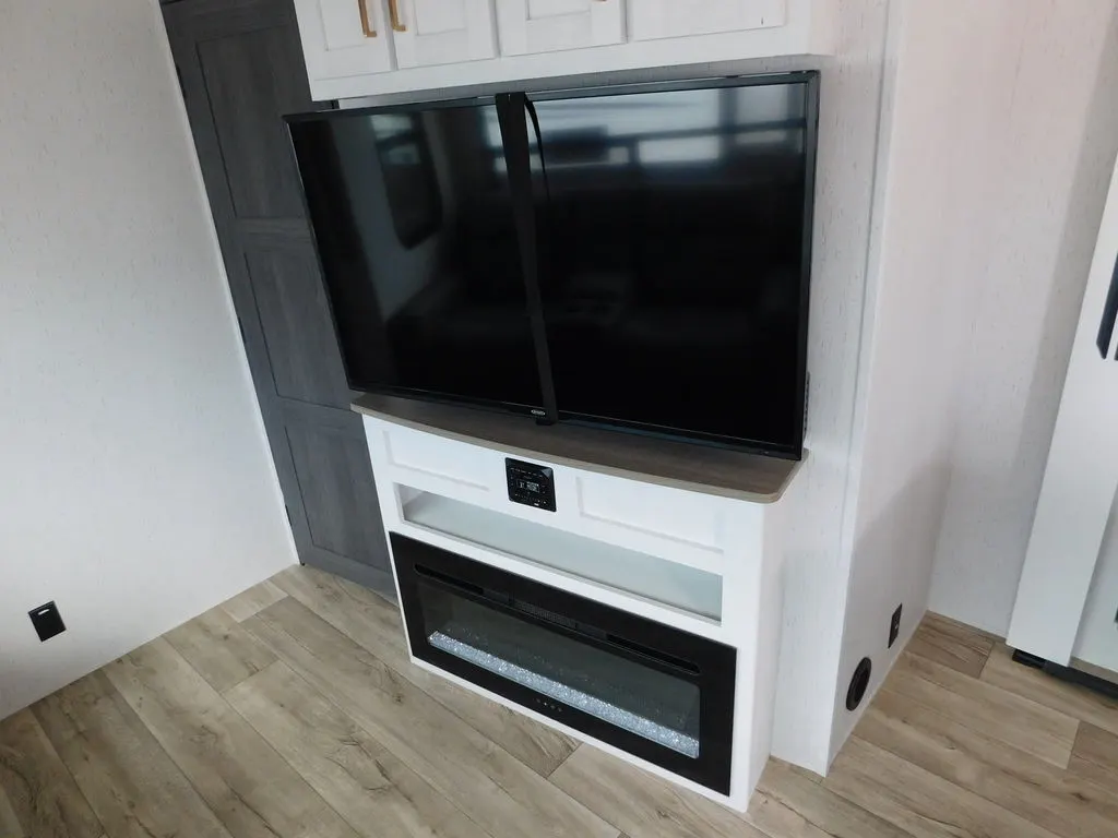 Entertainment center with a TV and a fireplace.