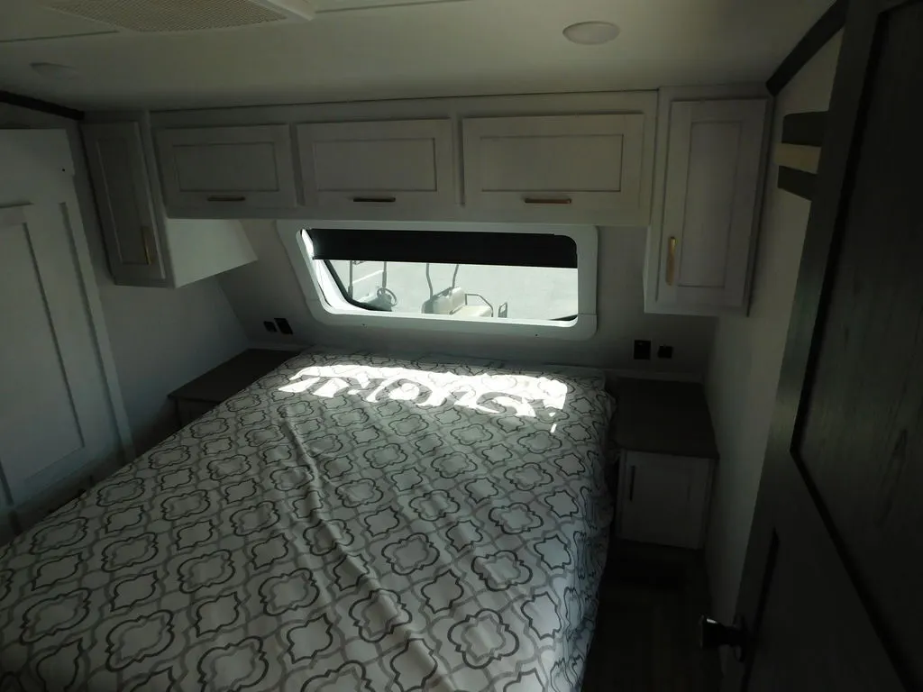 Bedroom with a king size bed, overhead cabinets and shirt closets.