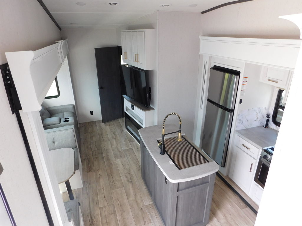 Interior view of the RV with a dinette, living space and a kitchen.