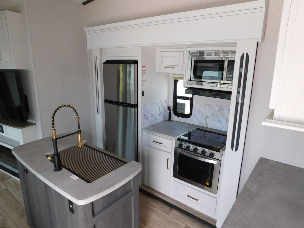 Kitchen with a gas range, fridge, oven, sink and cabinets.