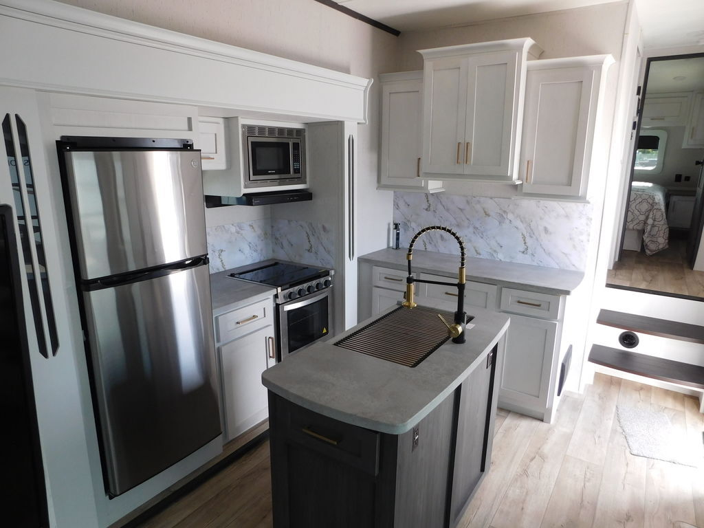 Kitchen with a gas range, fridge, oven, sink and cabinets.