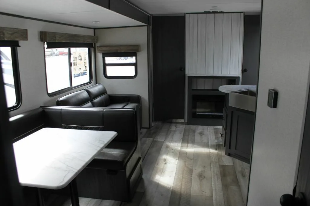 Interior view of the RV with a dinette, living space and a kitchen.