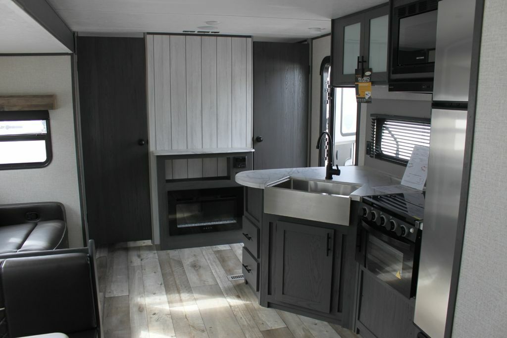 Kitchen with a gas burner, oven, sink and cabinets.