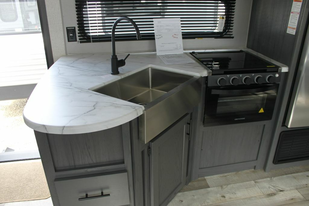 Kitchen with a gas burner, fridge, sink and cabinets.