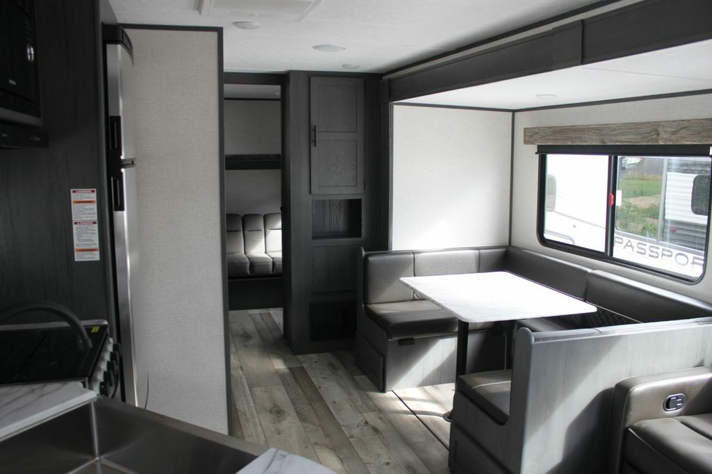 Interior view of the RV with a dinette, living space and a kitchen.