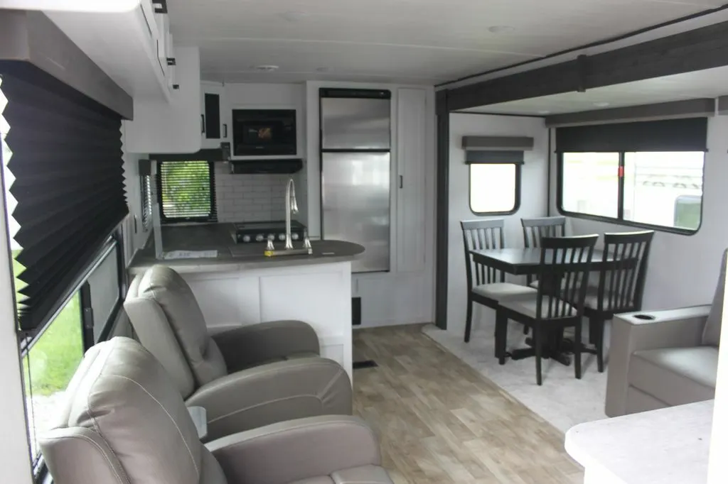 Interior view of the RV with a dinette, living space and a kitchen.