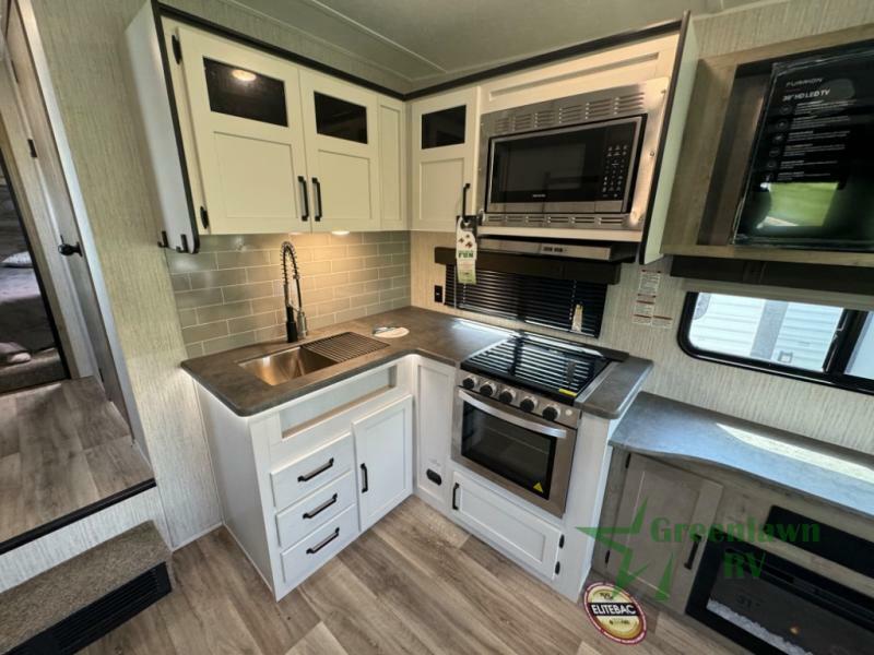 Kitchen with a gas burner, oven, sink and cabinets.