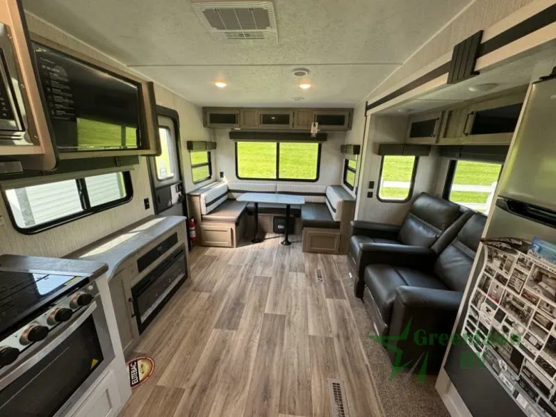 Interior view of the RV with a dinette, living space and a kitchen.