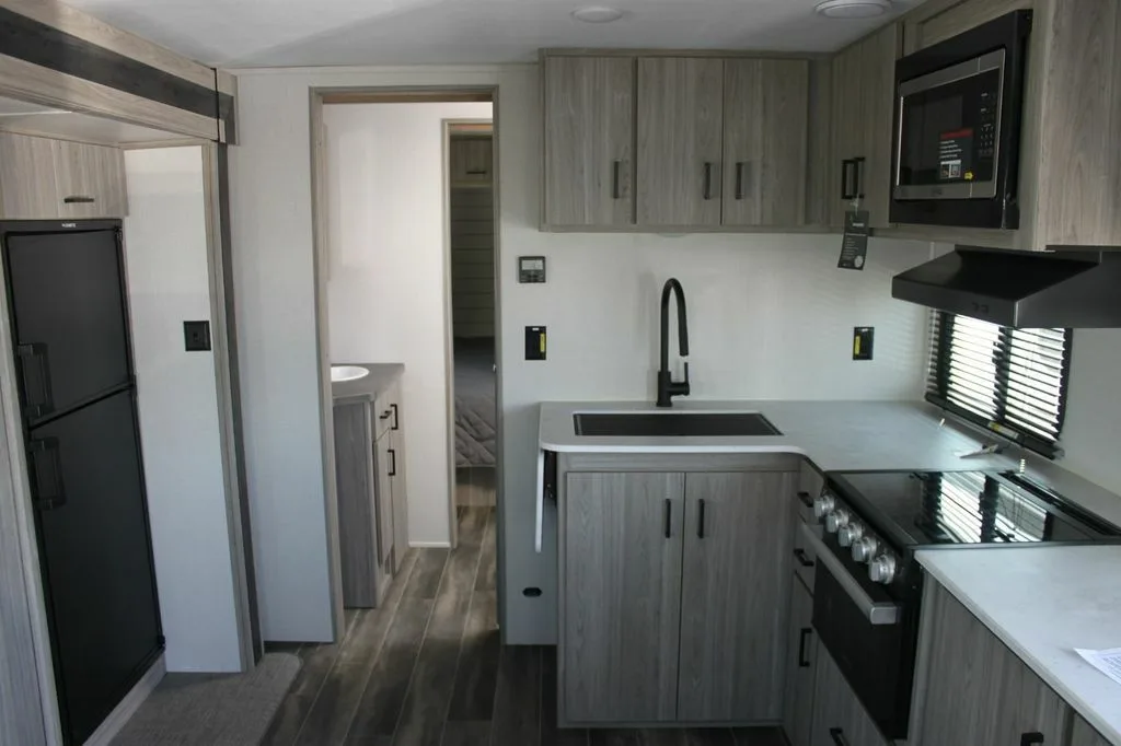 Kitchen with a gas burner, fridge, oven, sink and cabinets.