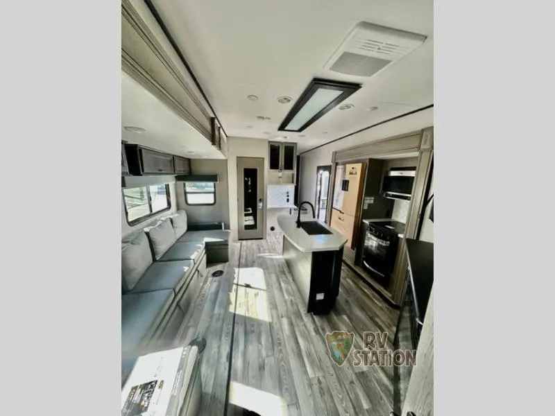 Interior view of the RV with a dinette, living space and a kitchen.