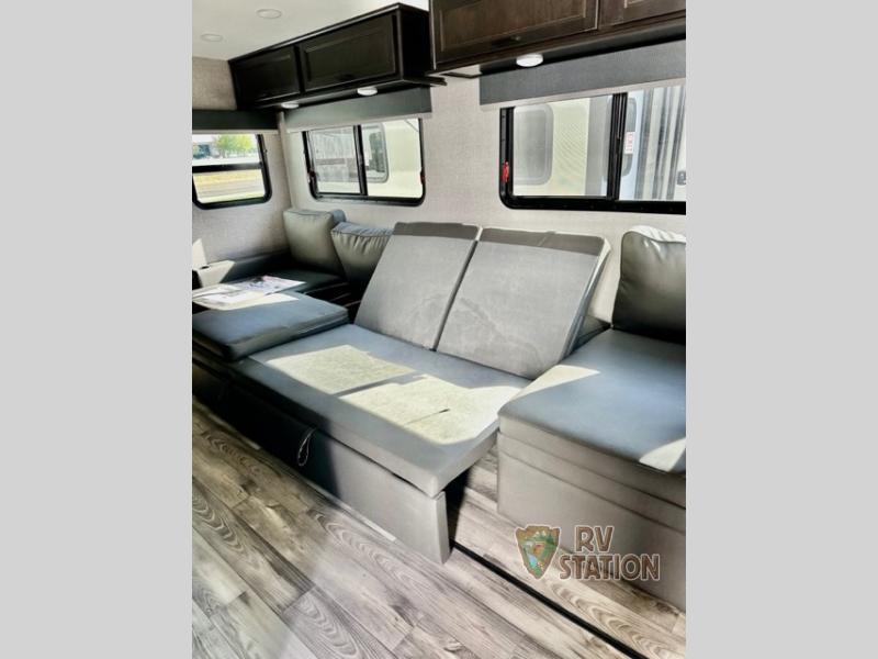 Living space with leather seats and overhead cabinets. 