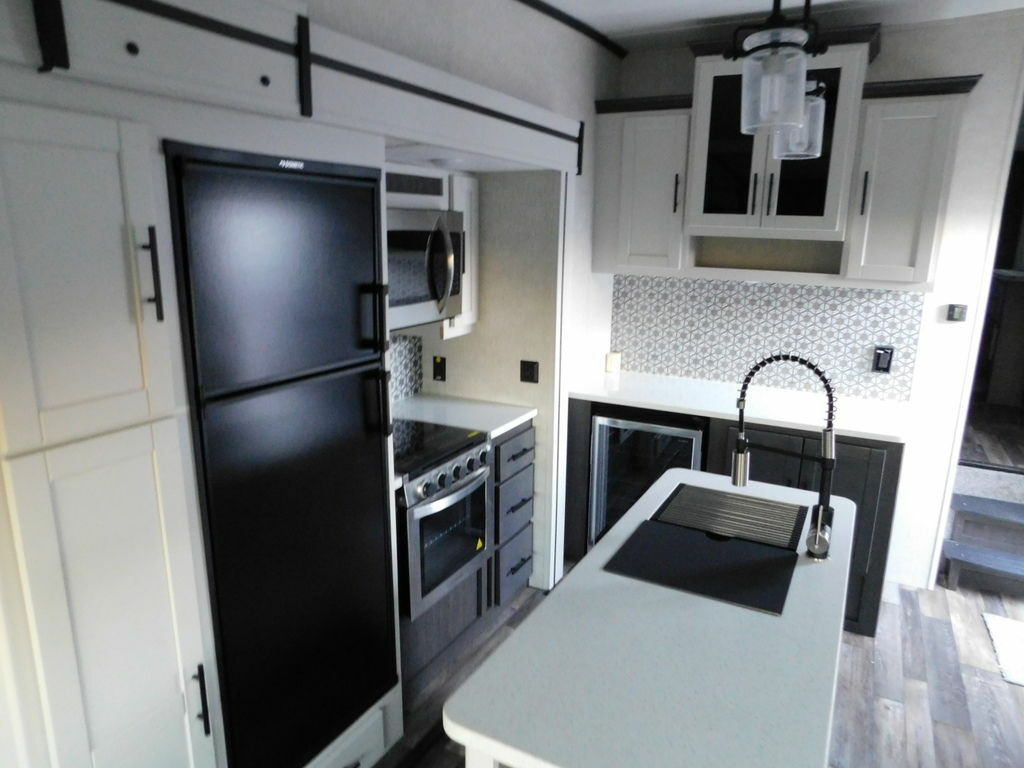 Kitchen with a gas burner, fridge, oven, sink and cabinets.