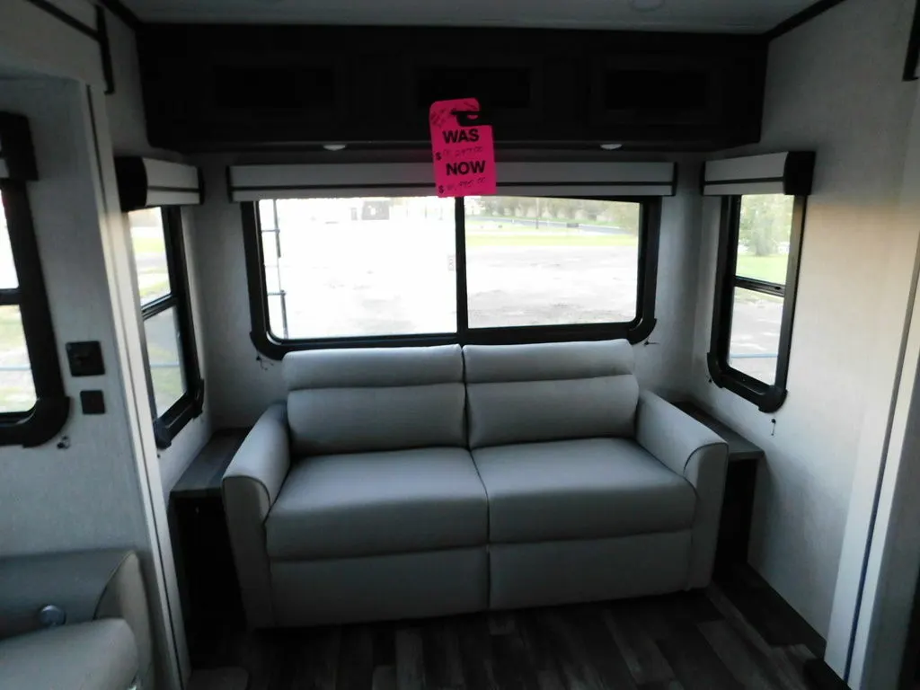 Living space with leather seats and overhead cabinets. 