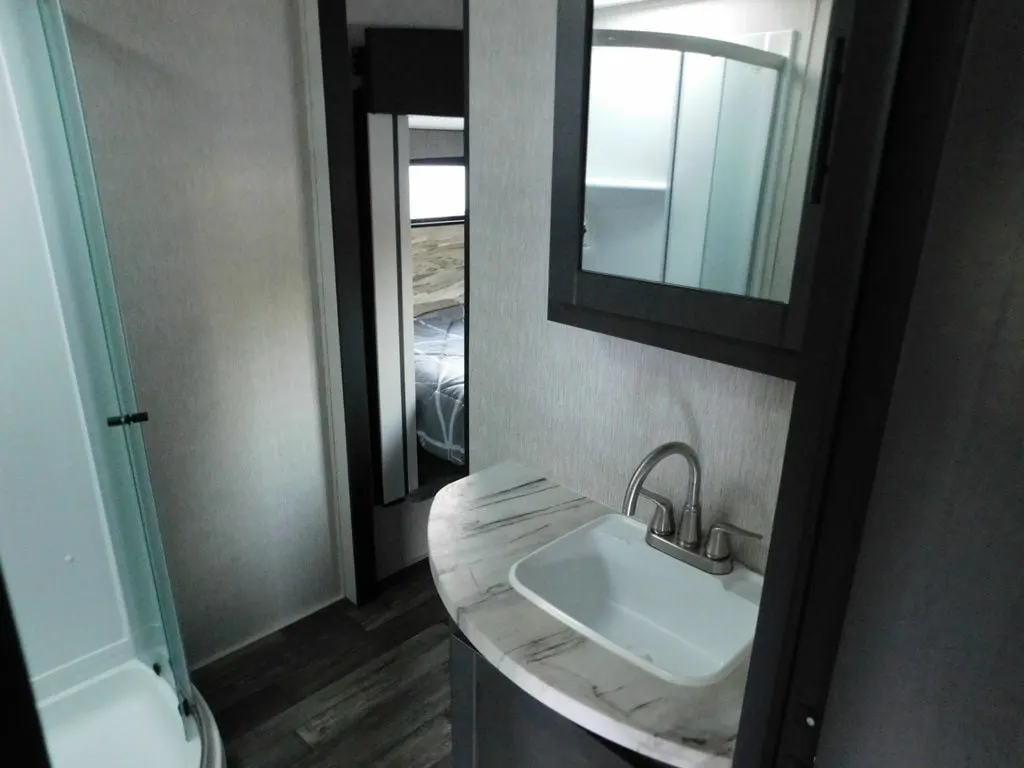 Bathroom with a sink, medicine cabinet and a walk-in shower.