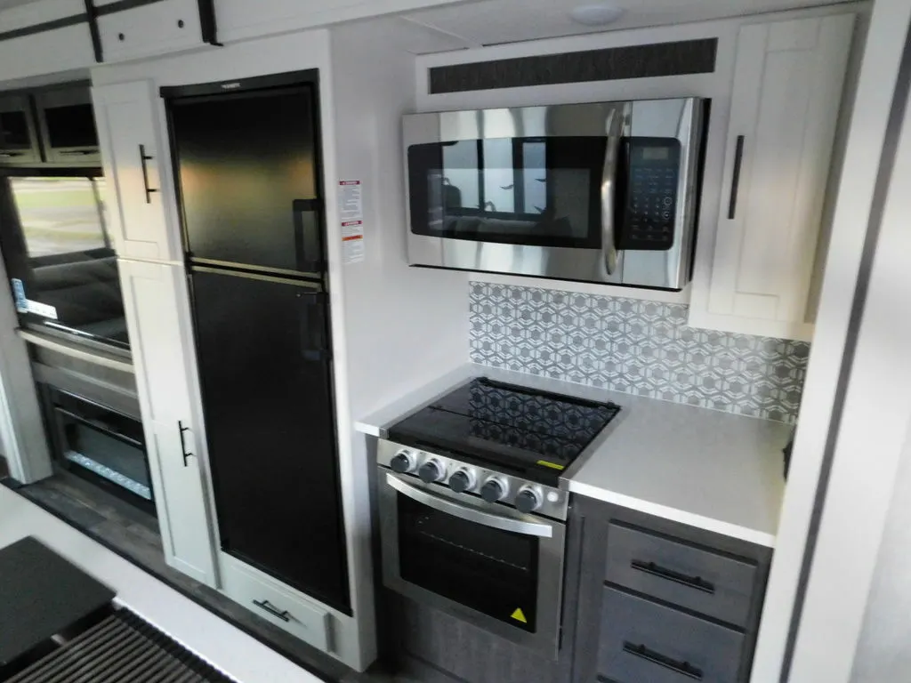 Kitchen with a gas burner, fridge, oven, and cabinets.