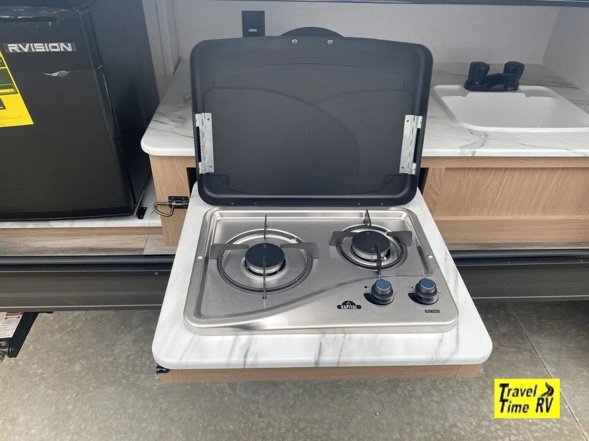 Outdoor kitchen with a gas burner, fridge and a sink.