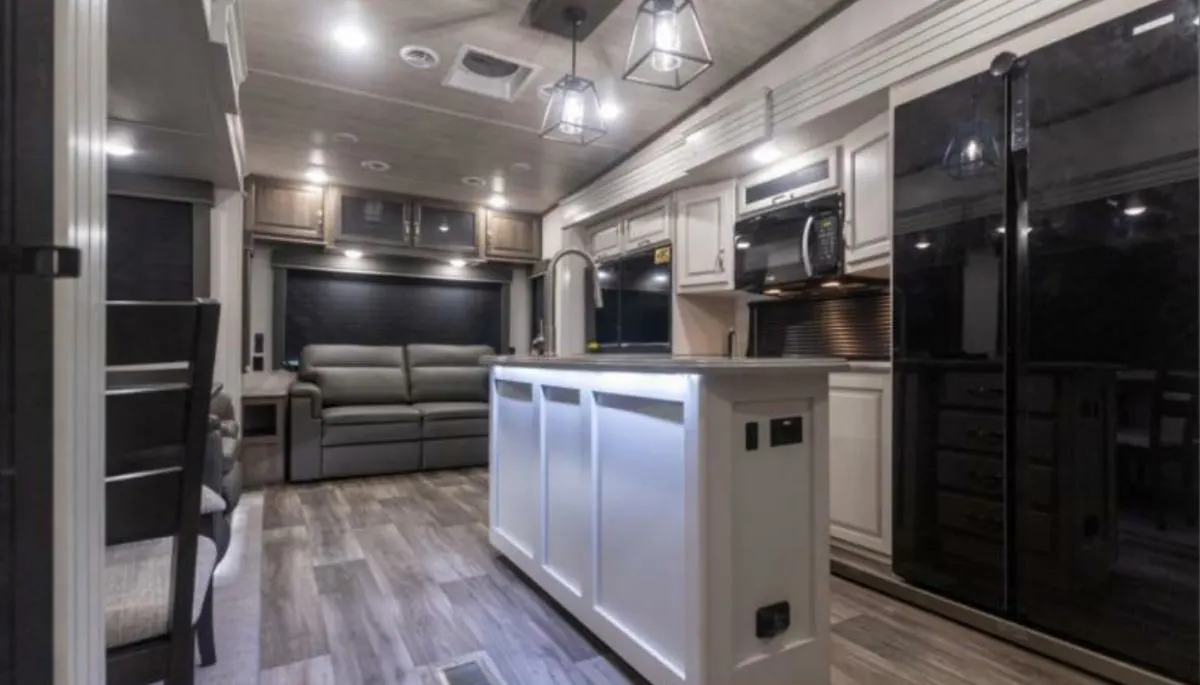 Interior view of the RV with a dinette, living space and a kitchen.