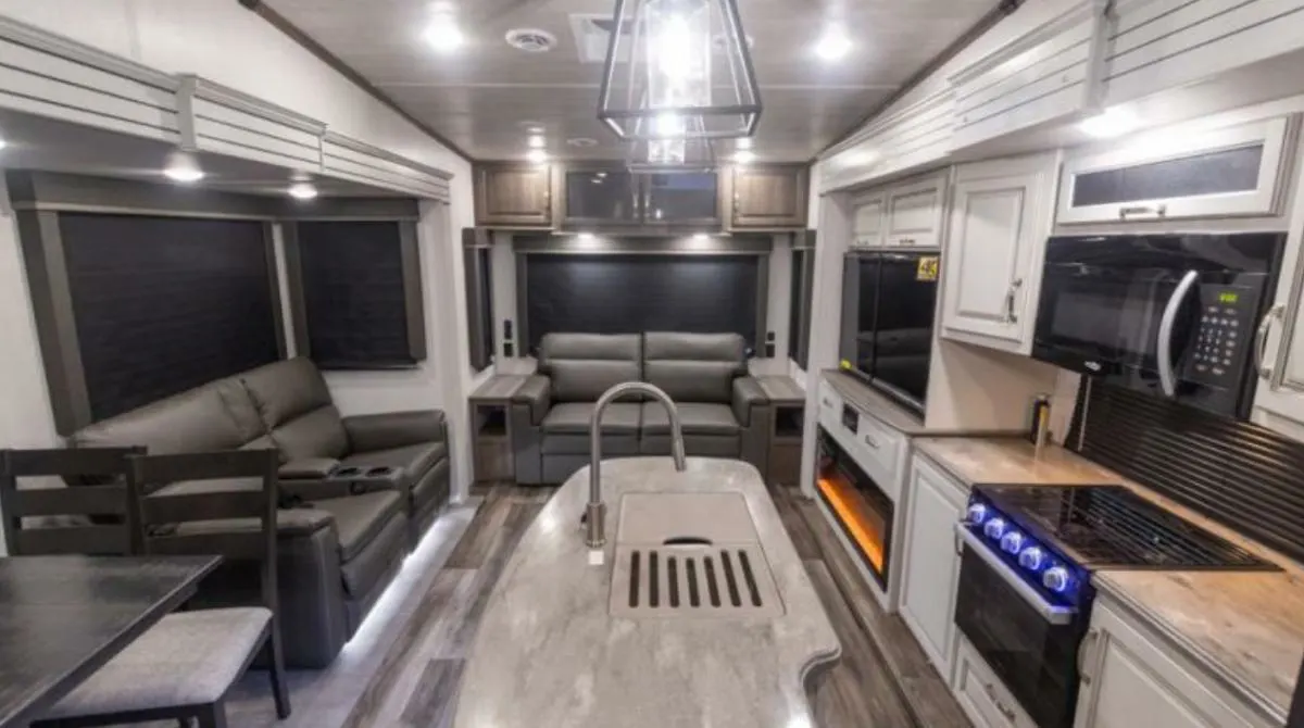 Interior view of the RV with a dinette, living space and a kitchen.