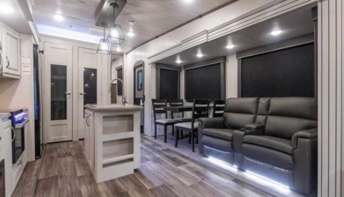 Interior view of the RV with a dinette, living space and a kitchen.