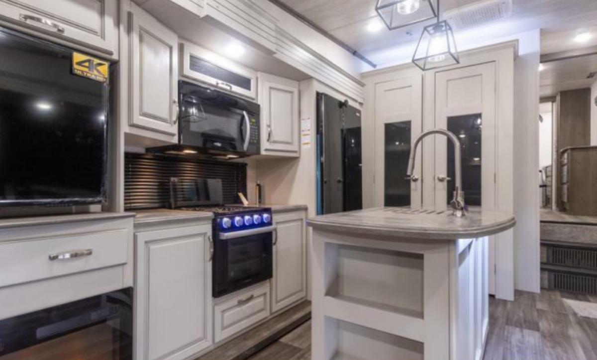 Kitchen with a gas burner, fridge, oven, sink and cabinets.