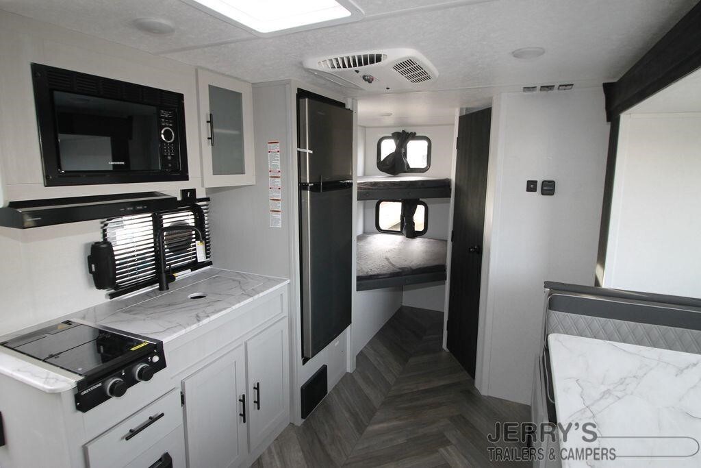 Interior view of the RV with a dinette, bedroom and a kitchen.