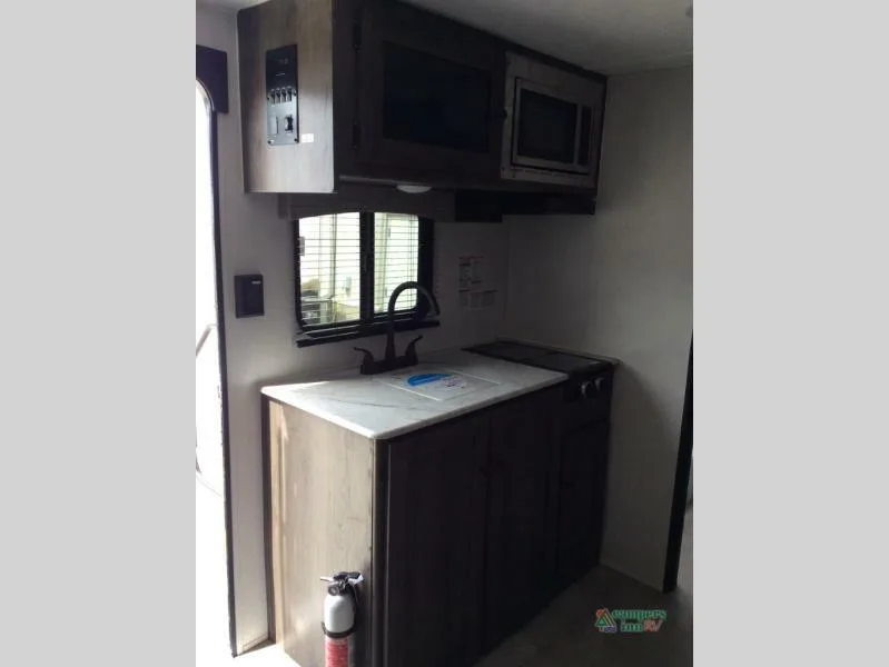 Kitchen with a gas burner, oven, sink and cabinets.