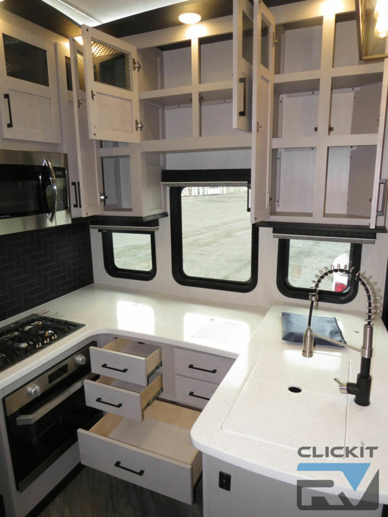 Kitchen with a gas burner, oven, sink and cabinets.