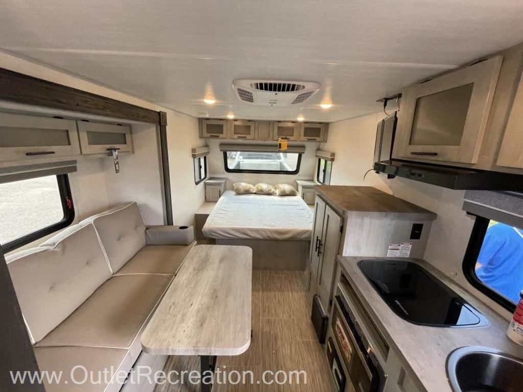 Interior view of the RV with a dinette, bedroom and a kitchen.