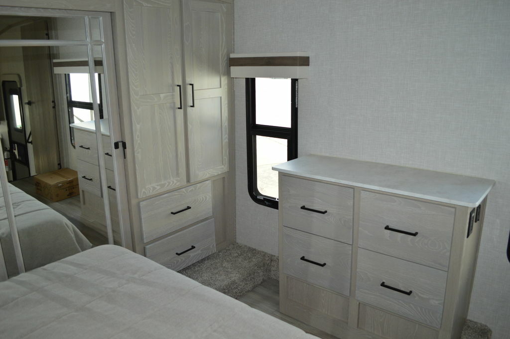 Bedroom with a queen size bed, dresser and a closet.