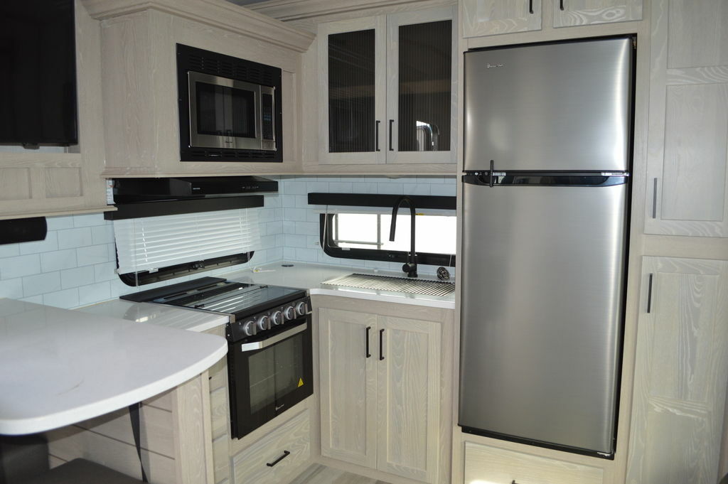 Kitchen with a gas burner, fridge, oven, sink and cabinets.