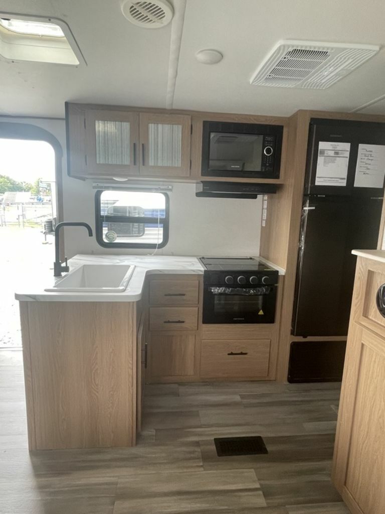 Kitchen with a gas burner, fridge, oven, sink and cabinets.