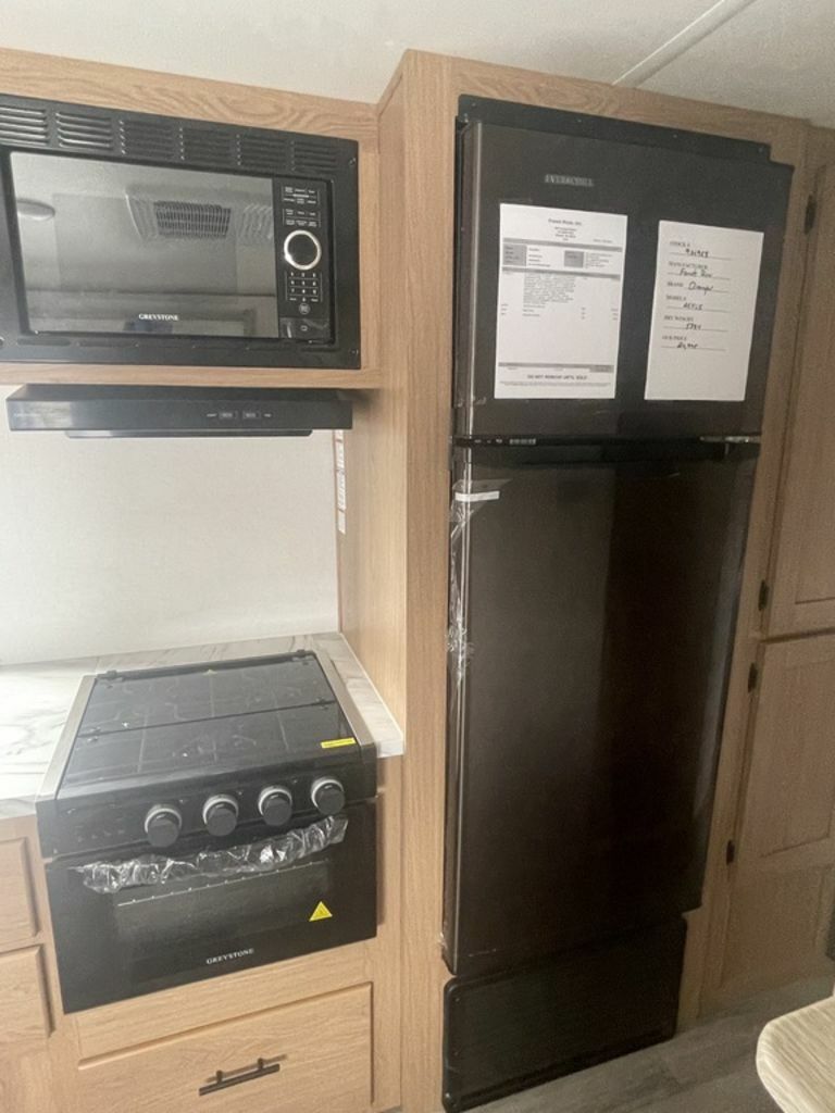 Kitchen with a gas burner, fridge, oven, and cabinets.