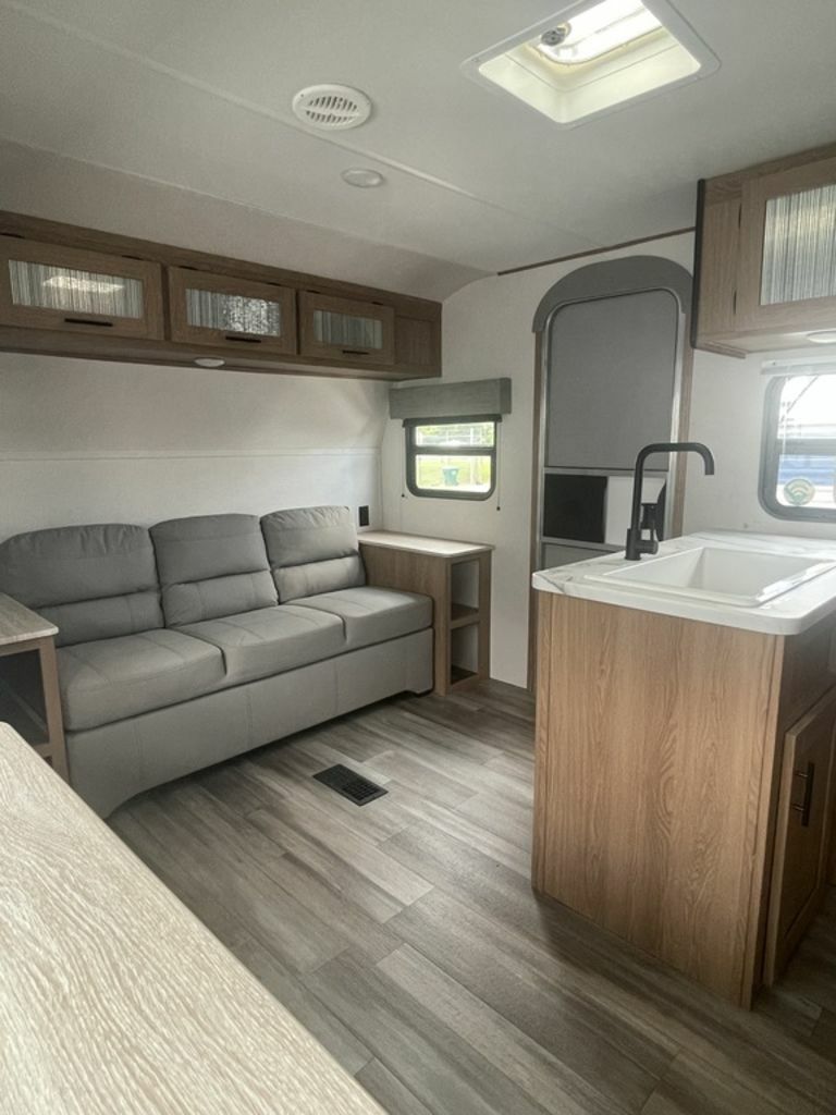 Living space with leather seats and overhead cabinets. 