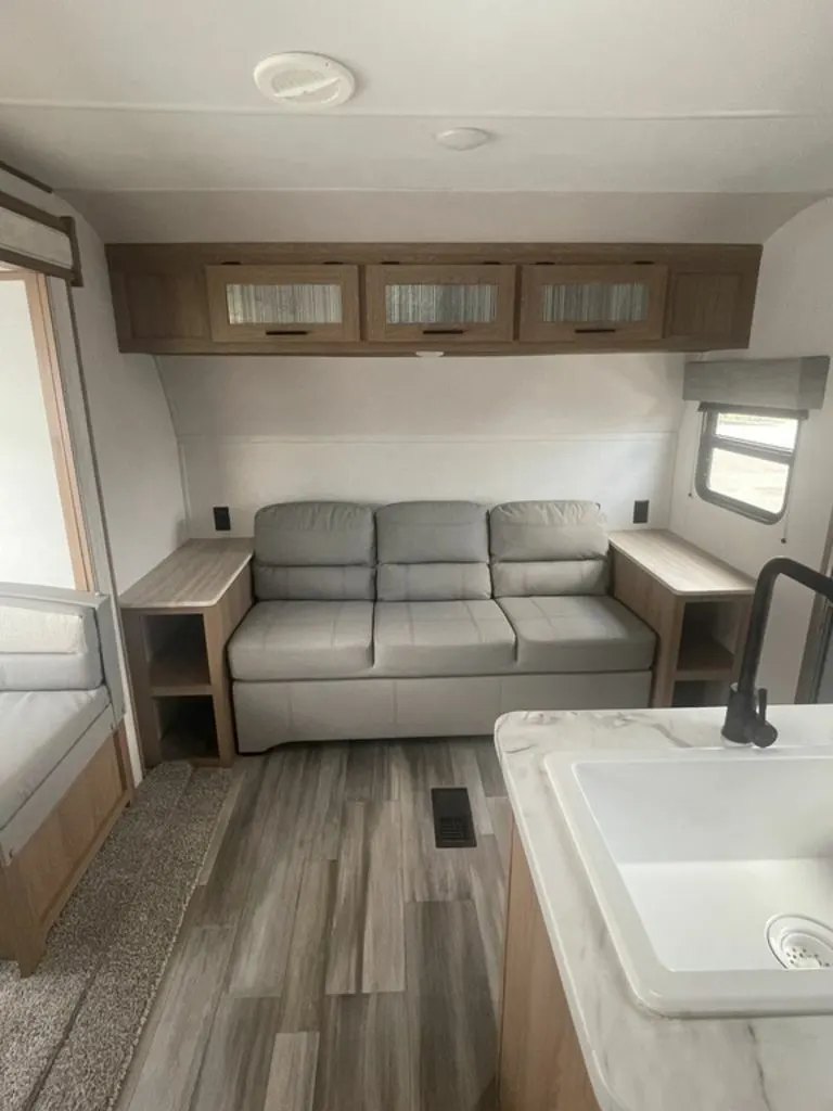 Living space with leather seats and overhead cabinets. 