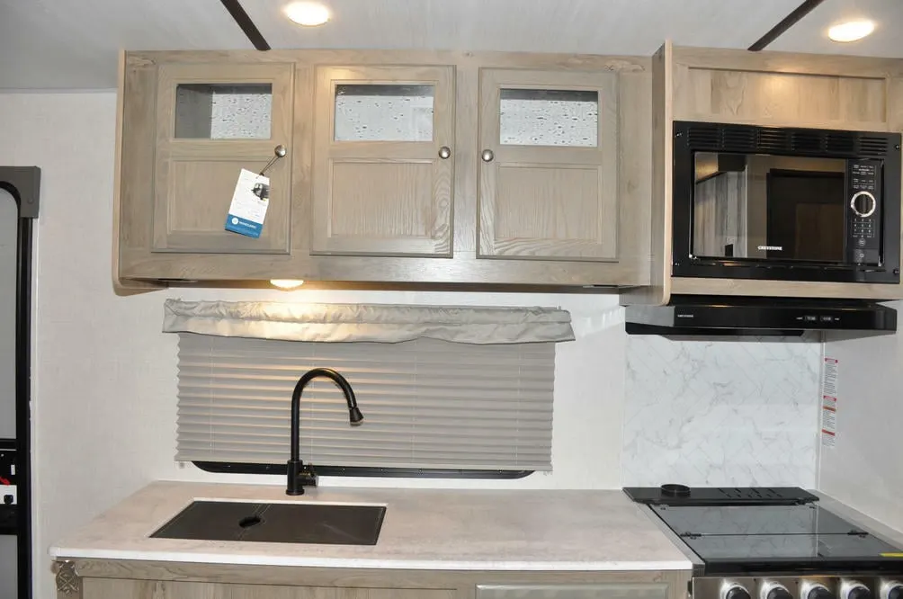 Kitchen with a gas burner,  oven, sink and cabinets.