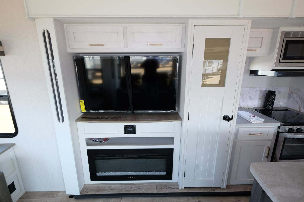 Entertainment center with a TV and a fireplace.