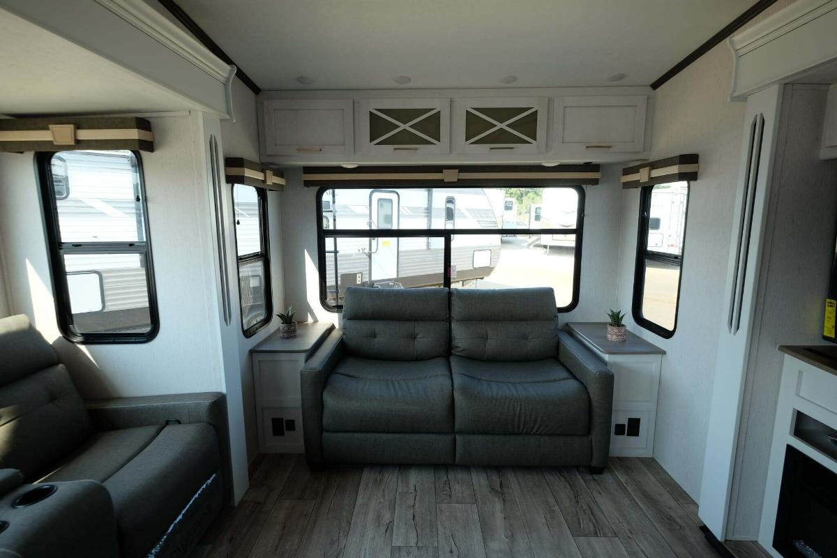 Living space with leather seats and overhead cabinets. 